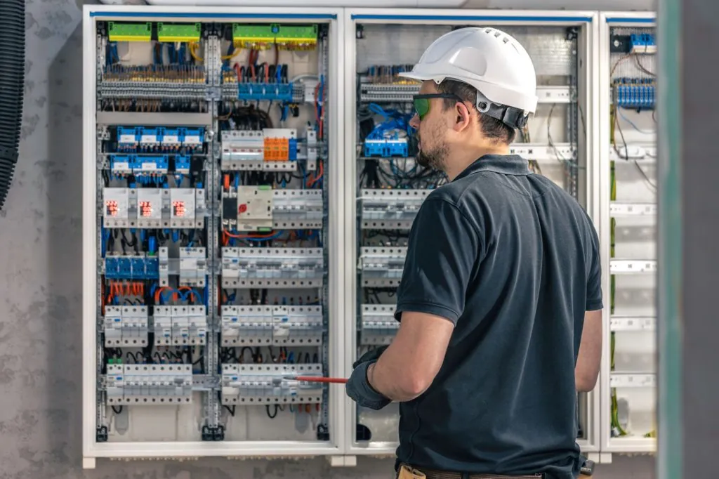 Eletricista trabalhando em quadro elétrico comercial